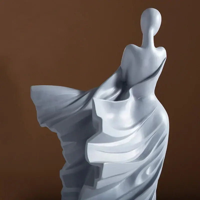 A sleek glossy white dancer figure resin sculpture with flowing draped attire from DecorBites abstract dancer collection