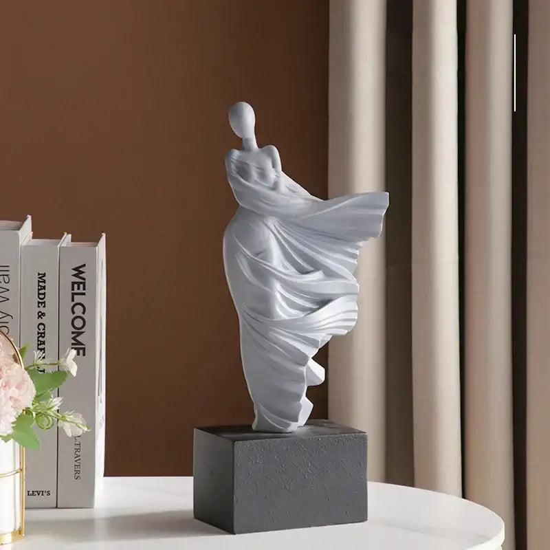 A sleek matte white dancer figure resin sculpture by decorbites abstract dancer on a textured dark gray base