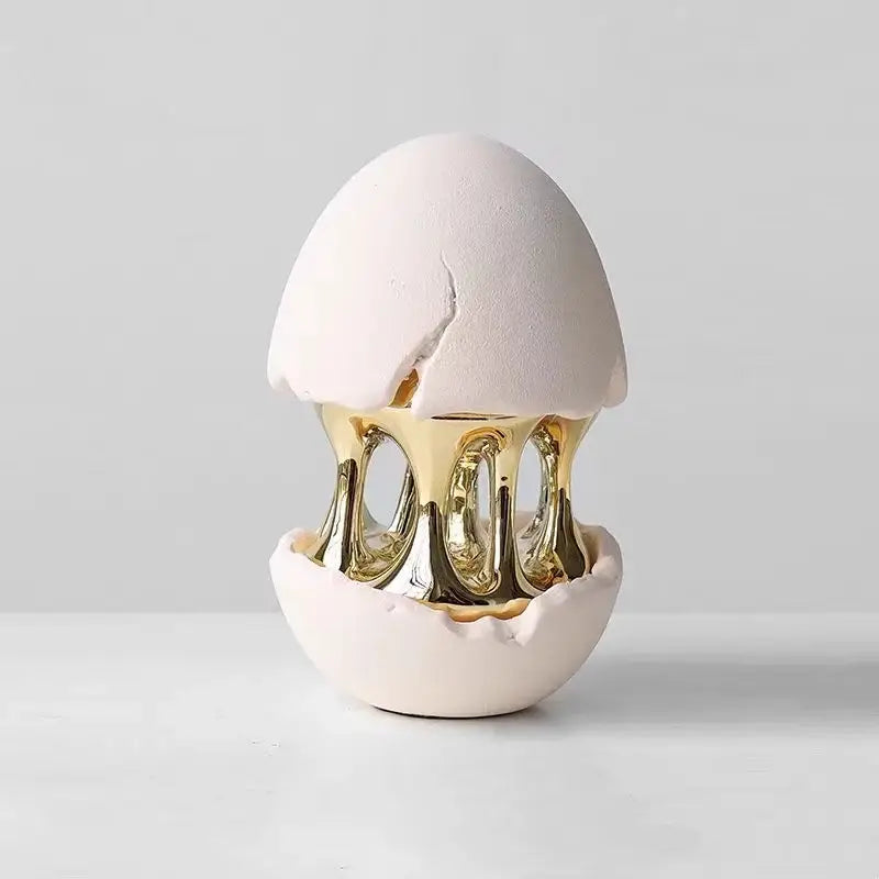 White ceramic decorbites abstract eggshell decorative figurine with cracked top and golden metallic hollow interior
