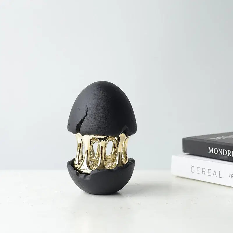 Black ceramic decorative figurine with gold interior featuring intricate interlocking rings in decorbites abstract eggshell hollow design
