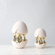 Two white ceramic decorative figurines with gold metallic interiors and cracked shells from DecorBites abstract eggshell hollow collection