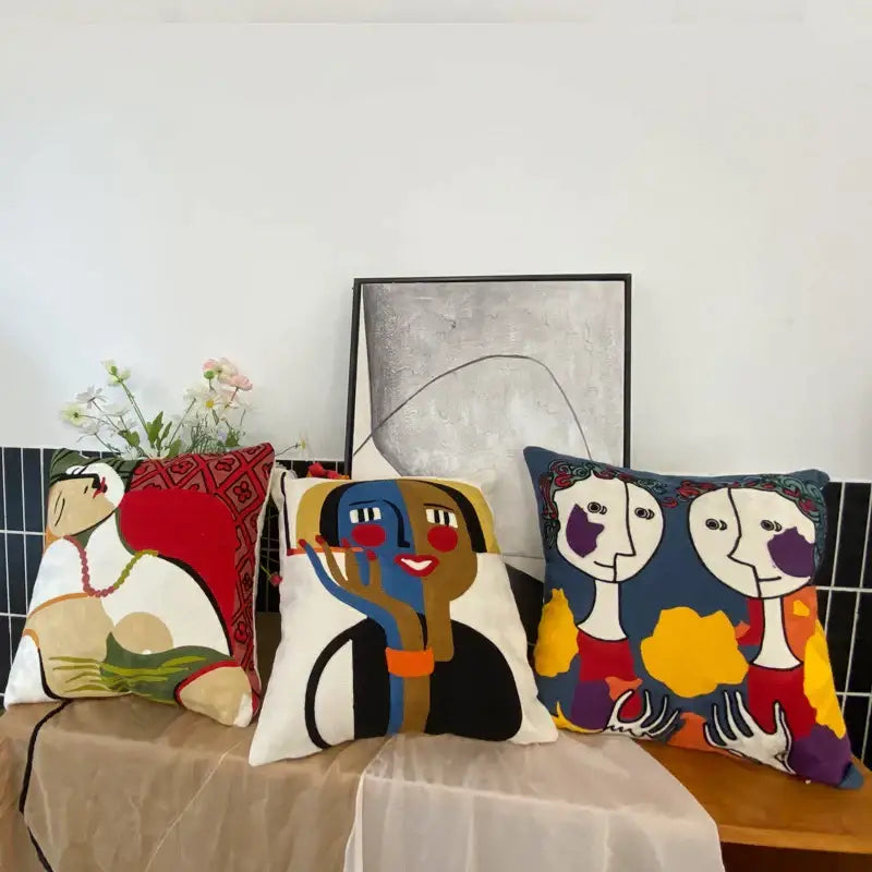 Three colorful decorbites abstract embroidery throw pillows with vibrant stylized faces in abstract embroidery pillowcase design