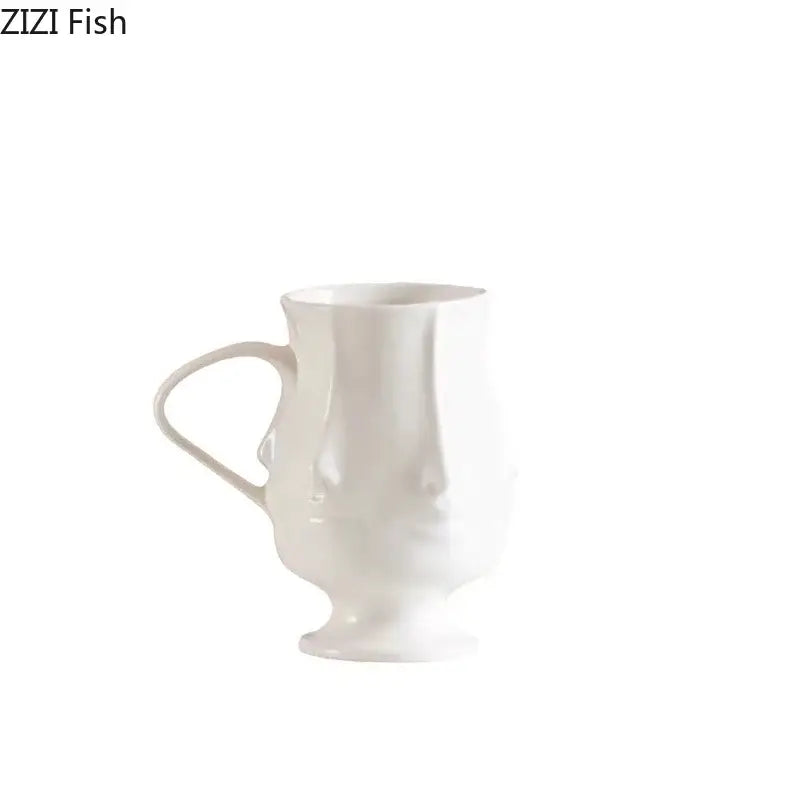 White ceramic mug with sculpted abstract face design handle and pedestal base by decorbites abstract face ceramic