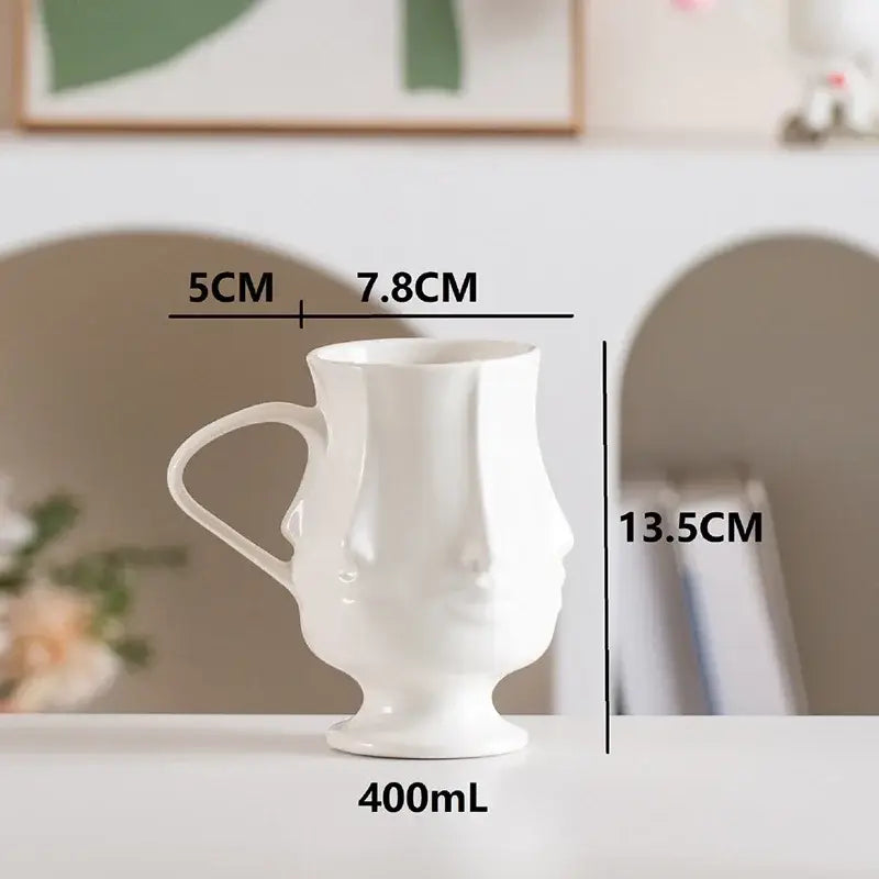White ceramic decorbites abstract face coffee mug with sculpted face design and 400ml capacity for dining table use