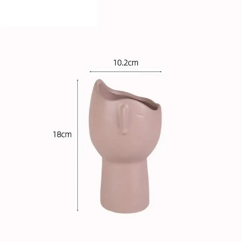 A blush pink decorbites abstract face ceramic vase with minimalist features for table flower decoration