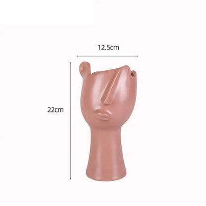 A sleek matte rose gold abstract face ceramic planter by decorbites designed for table flower decoration