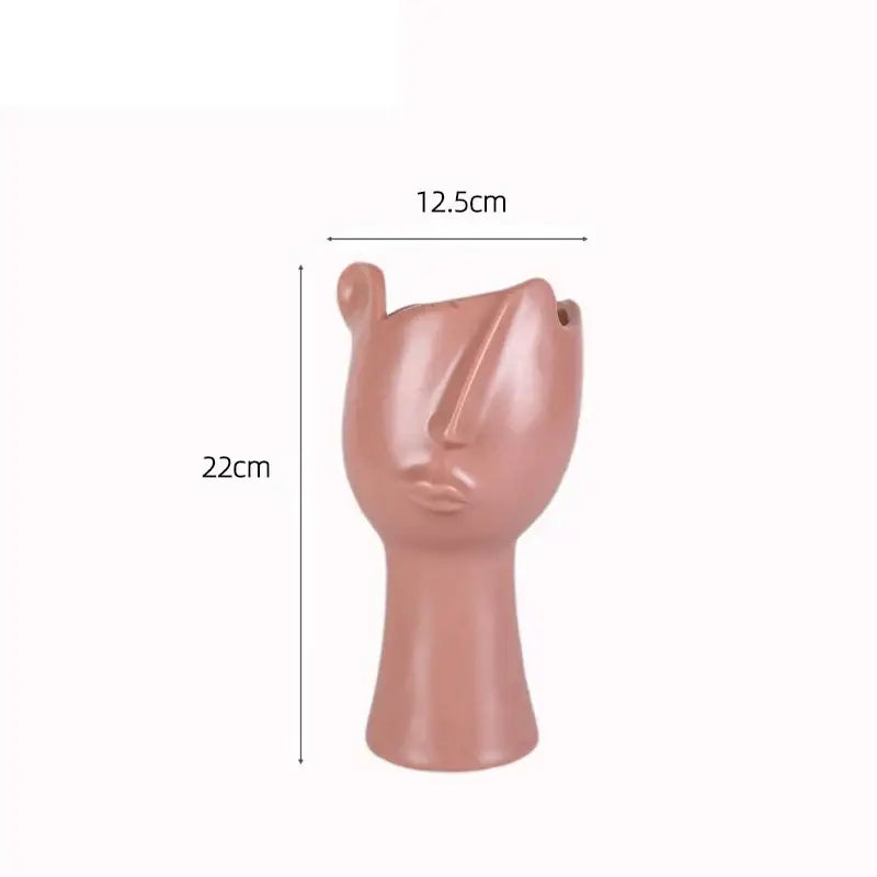 A sleek matte rose gold abstract face ceramic planter by decorbites designed for table flower decoration