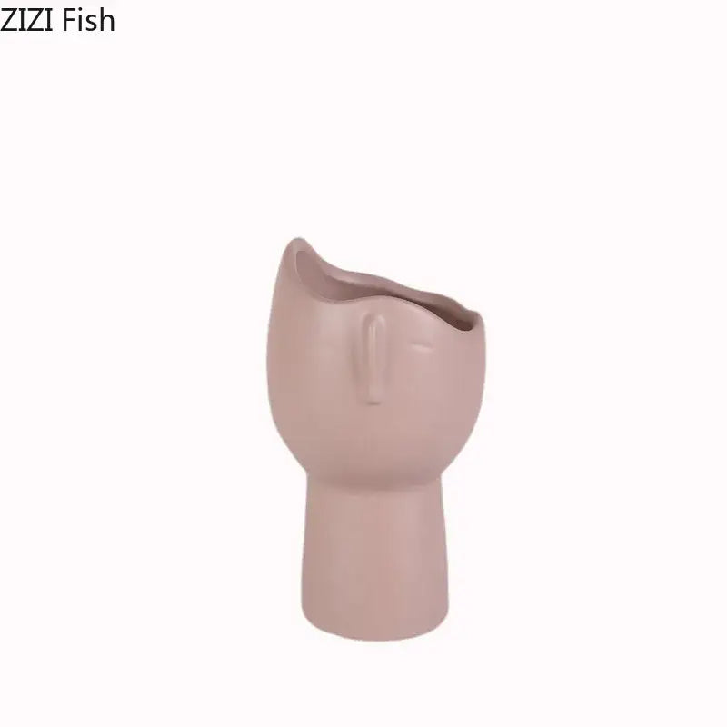 A blush pink DecorBites™ abstract face ceramic vase with minimalist features for table flower decoration