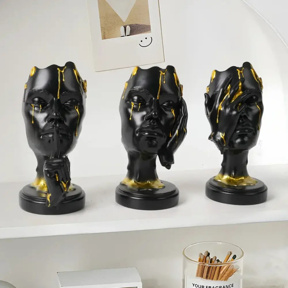 Three black resin decorbites abstract face mask statues with gold drips and hand gestures for home decor