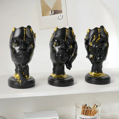 Three black resin decorbites abstract face mask statues with gold drips and hand gestures for home decor