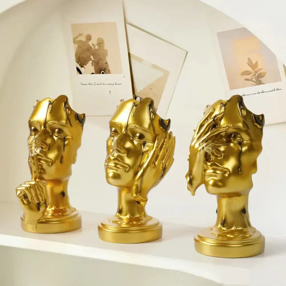 Three golden glossy resin busts with expressive abstract face mask hand gestures for home decor by decorbites abstract face