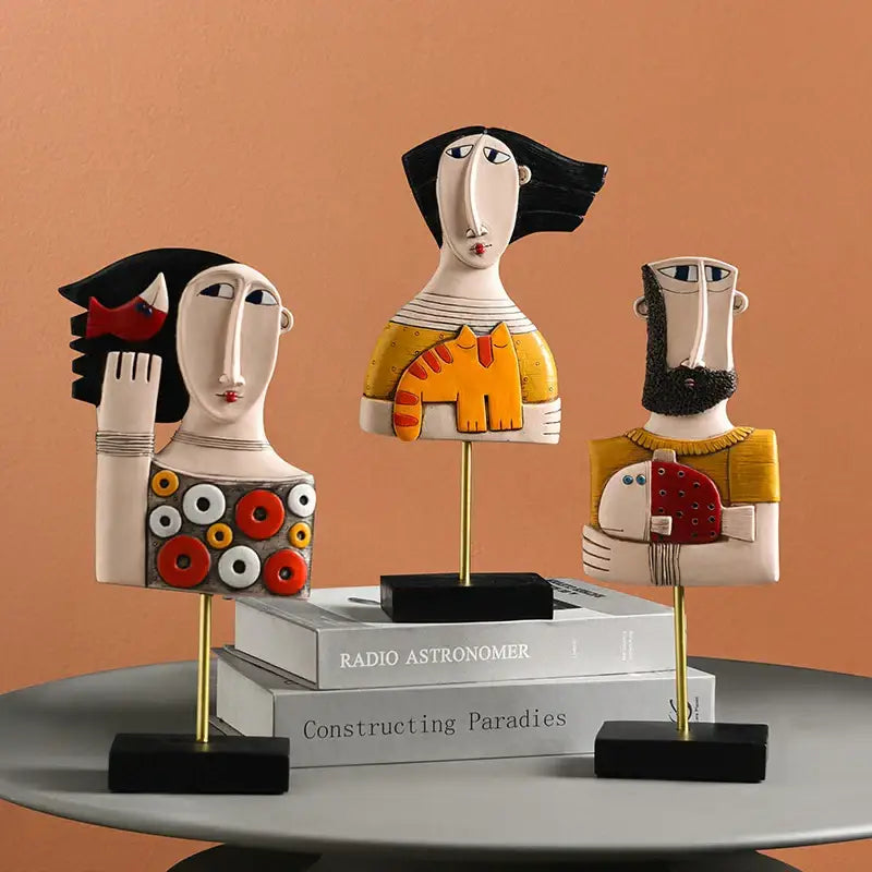 Three stylized ceramic decorbites abstract face resin figurines with bold black white yellow and red accents for home decor