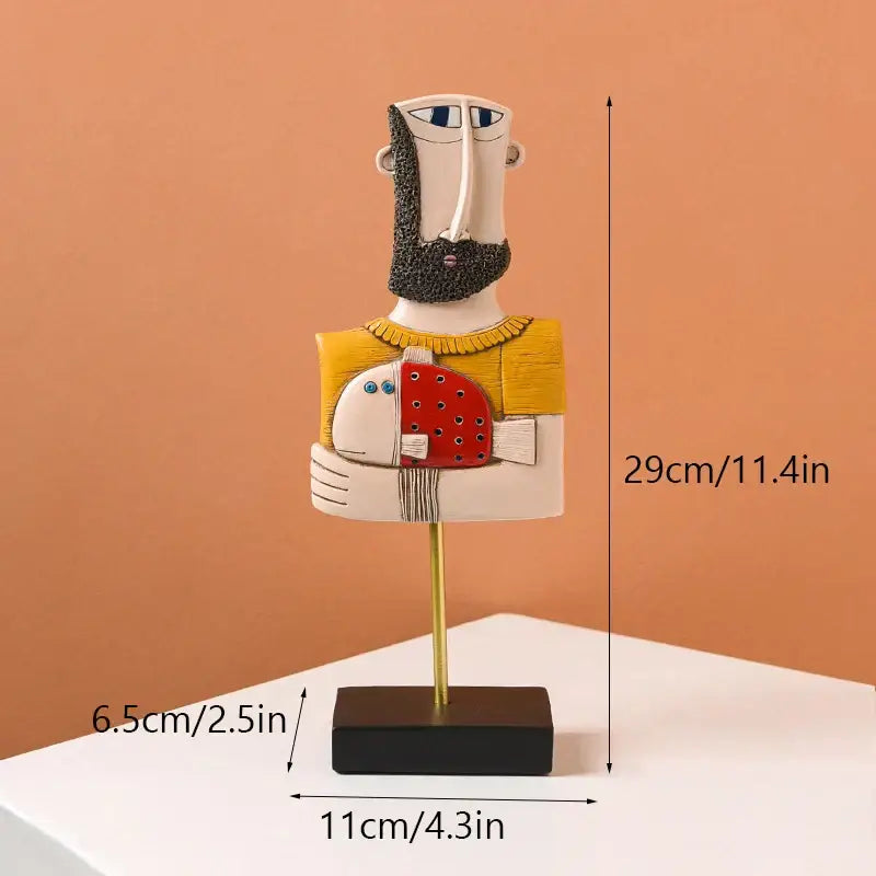 Stylized ceramic decorbites abstract face resin art figurine of a bearded man in yellow sweater holding red fish