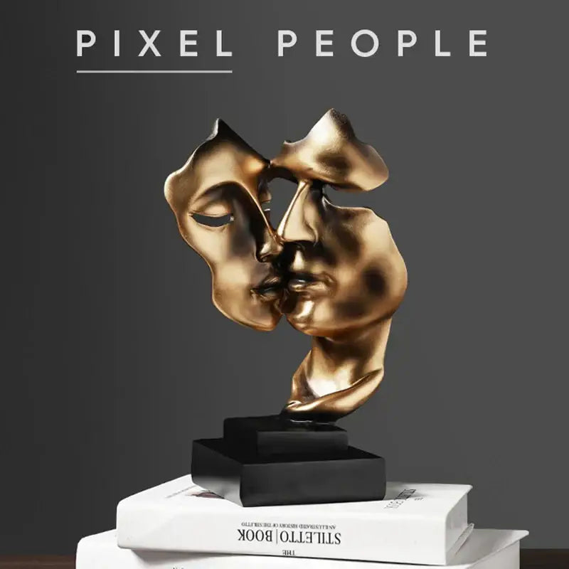 Golden metallic abstract face sculpture ornament of two faces in close embrace on black base for home decor and gifts