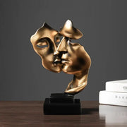 Golden metallic abstract face sculpture ornament of two faces kissing on a black base for home decor and wedding gift