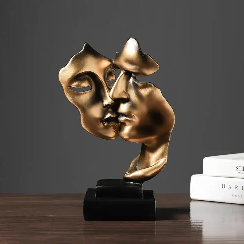 Golden metallic abstract face sculpture ornament of two faces kissing on a black base for home decor and wedding gift