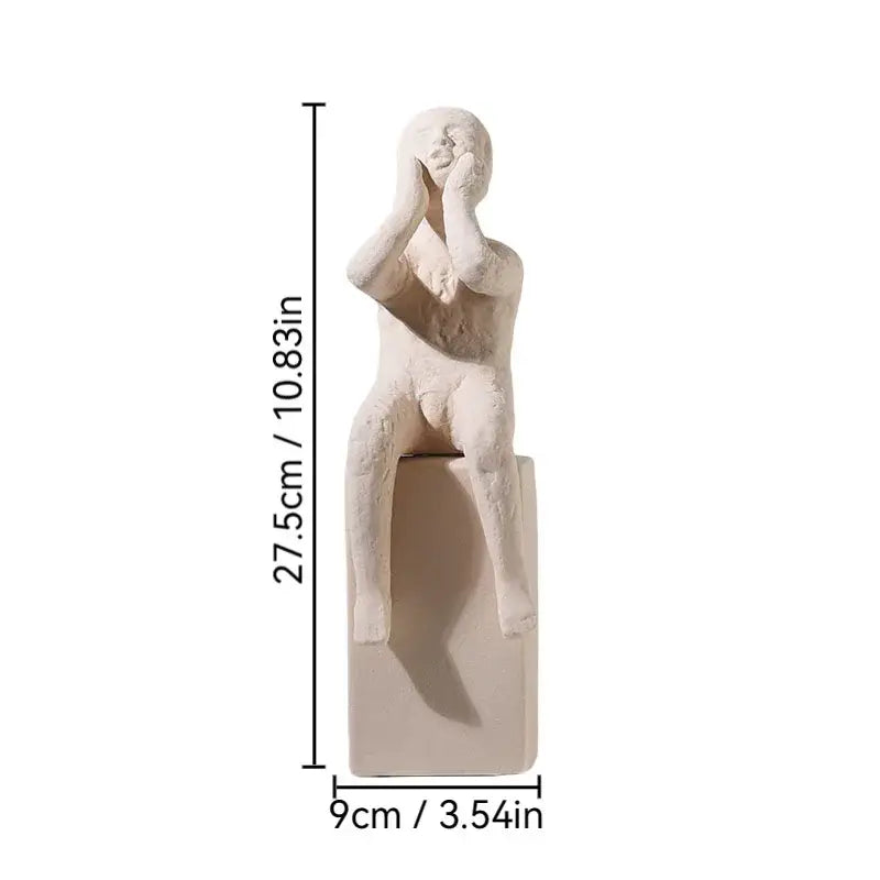 Cream-colored decorbites abstract family resin sculpture of seated figure with hands covering face on matching base