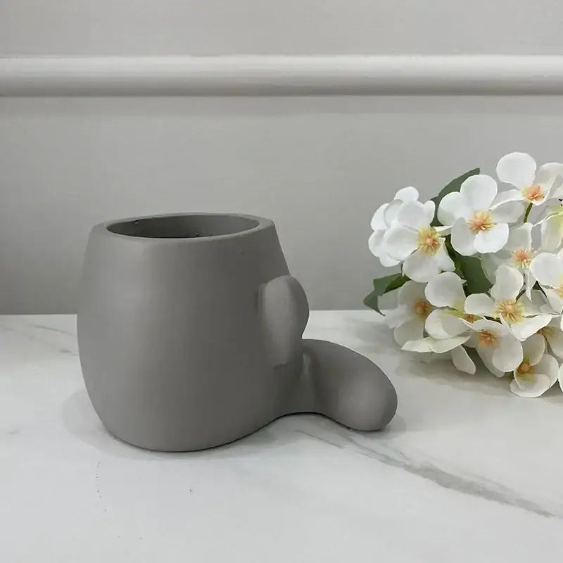 Gray ceramic flowerpot ornament shaped like a minimalist bear head from decorbites abstract family collection