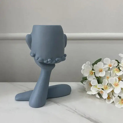 A matte gray ceramic decorbites abstract family flowerpot ornament shaped like a stylized head with ruffled details