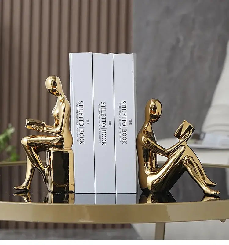 Golden metallic decorbites abstract figure bookend set shaped like seated human figures for stylish home decor