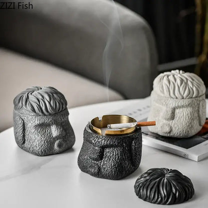 Black textured figure portraits cement ashtray shaped like a human head with gold-colored inner tray and lid for smoking accessories