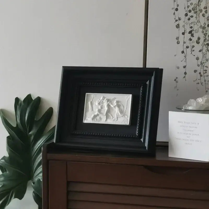Black framed white relief sculpture featuring two abstract figures in a dynamic scene decorbites abstract figure decorative painting