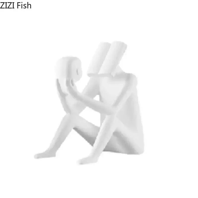 White resin decorbites abstract figure sculpture depicting two stylized human figures in intimate seated pose for room decor