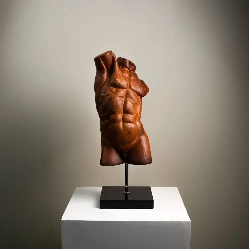 Bronze-colored decorbites abstract figure sculpture of a male torso with defined abs on a black stand decorative figurine
