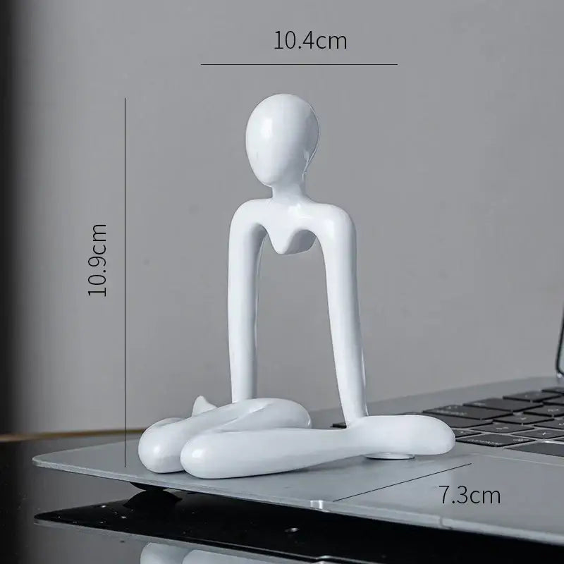 White glossy resin decorbites abstract figures ornament sculpture of a minimalist seated human form for home office decor