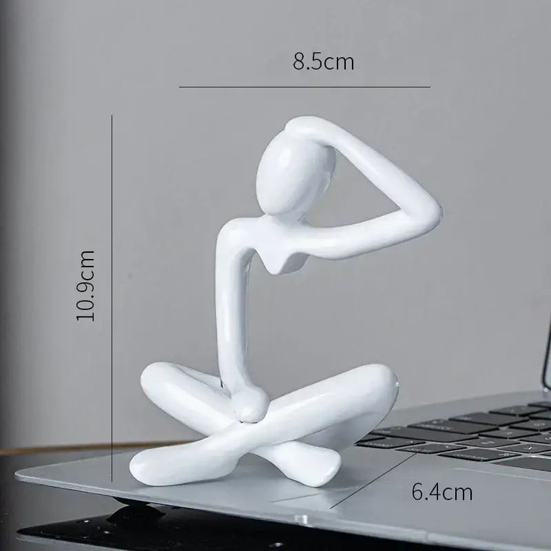 White glossy resin decorbites abstract figures ornament sculpture of a seated human figure with arms raised to head