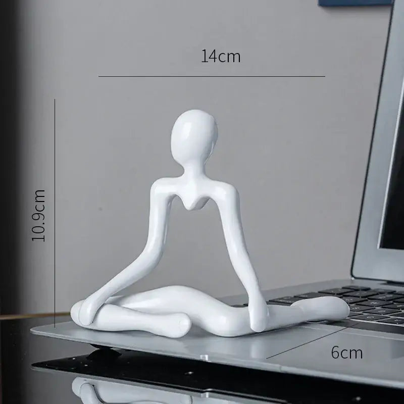 White glossy resin decorbites abstract figures ornament sculpture depicting a stylized human in meditation pose