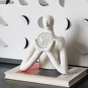 White speckled resin decorbites abstract figures sculpture holding clear glass orb with silver leaf design for sculpture decor