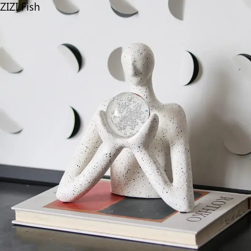 White speckled resin decorbites abstract figures sculpture holding clear glass orb with silver leaf design for sculpture decor