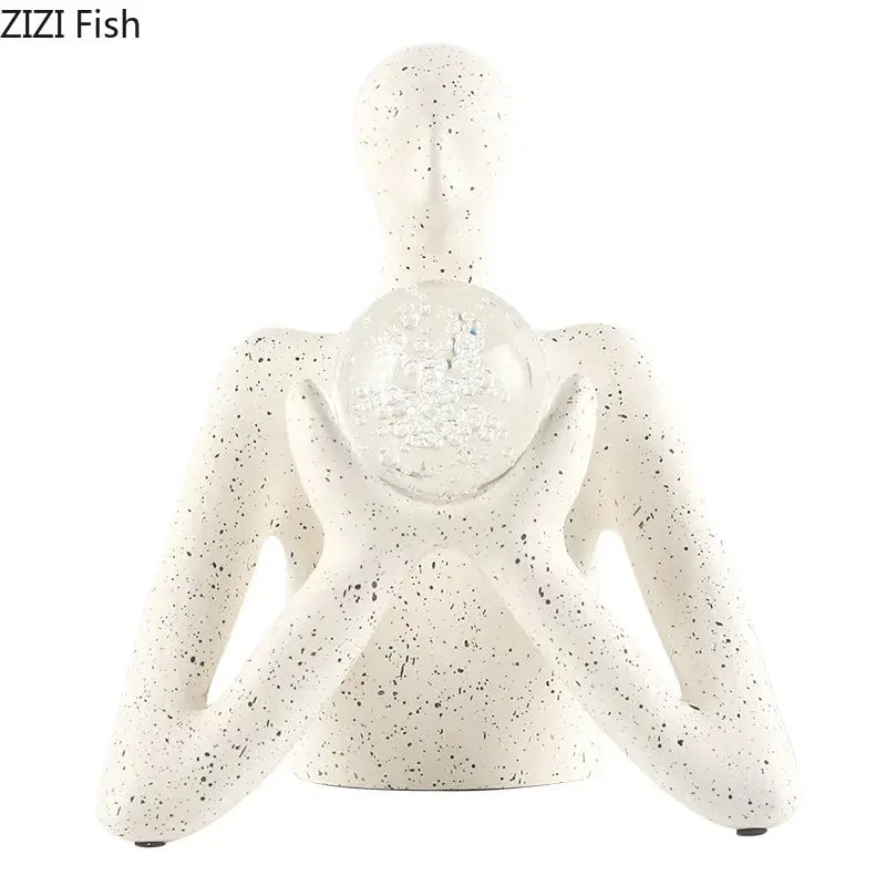 White speckled resin abstract figures sculpture by decorbites holding a clear glass sphere filled with glitter for sculpture decor
