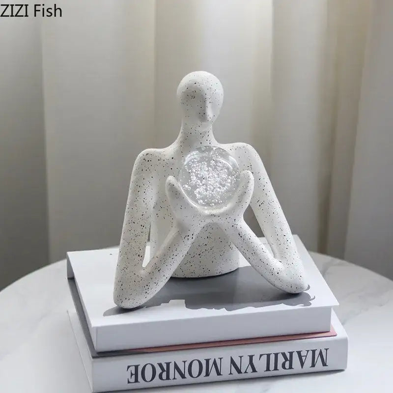 White speckled ceramic decorbites abstract figures sculpture holding clear glass orb for sculpture decor and room aesthetics