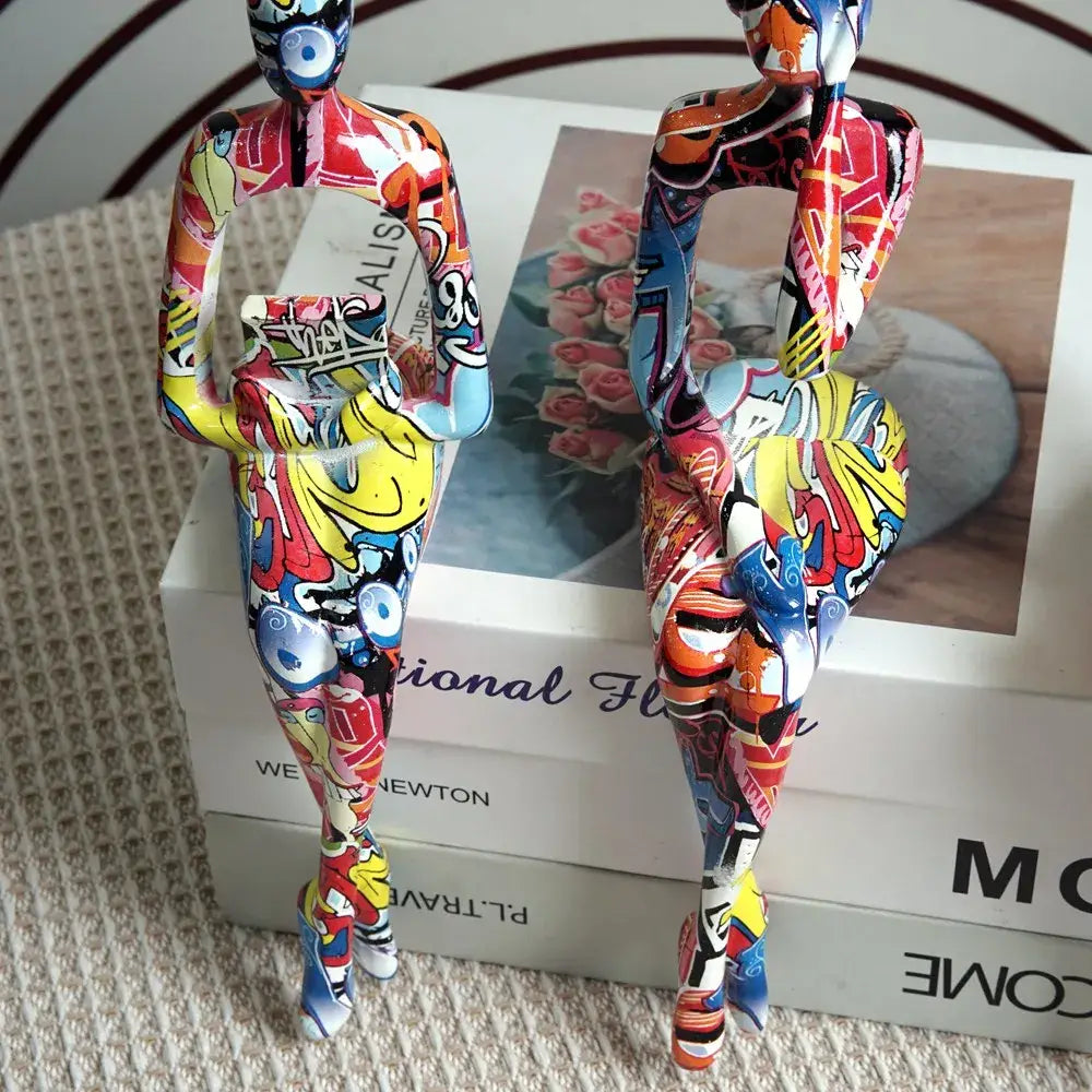 Two vibrant decorbites abstract figurine modern sculptures in bold red yellow and blue for home decor on glossy surface