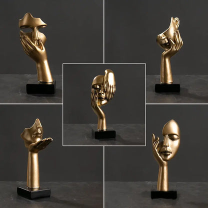 Golden metallic decorbites abstract figurines sculpture of a hand cradling a stylized face on a black base for home decor
