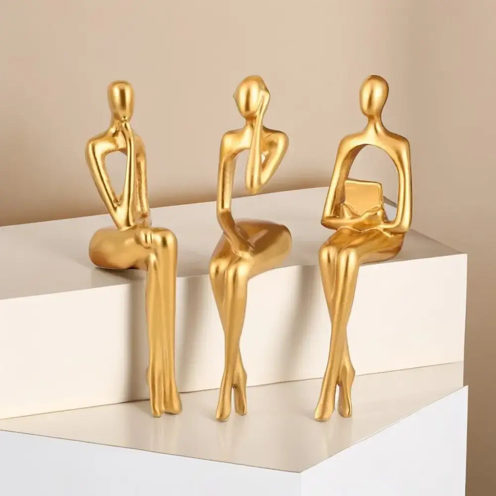Three sleek golden decorbites abstract figurines set with minimalist metallic finish for modern home and office decor