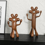 Two brown wooden decorbites abstract flower man figurines with rounded shapes and central head holes for home decor