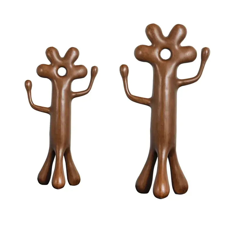 Two bronze-colored decorbites abstract flower man figurine hooks with rounded limbs and central hanging holes for home decor