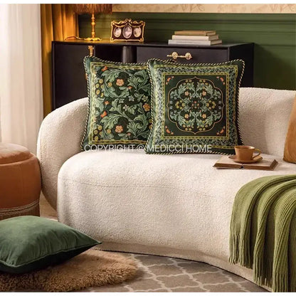 Two dark green velvet decorbites acanthus scroll leaves accent pillow cases with floral embroidery on cream sofa