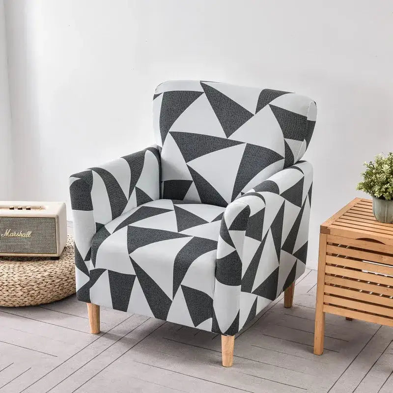 A modern accent chair with a bold black and white geometric chair cover slipcover and light wooden legs by DecorBites