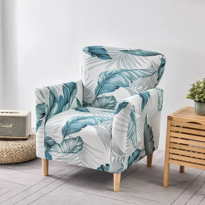 Cozy accent chair with teal and gray tropical leaf pattern fabric stretch chair cover slipcover white base