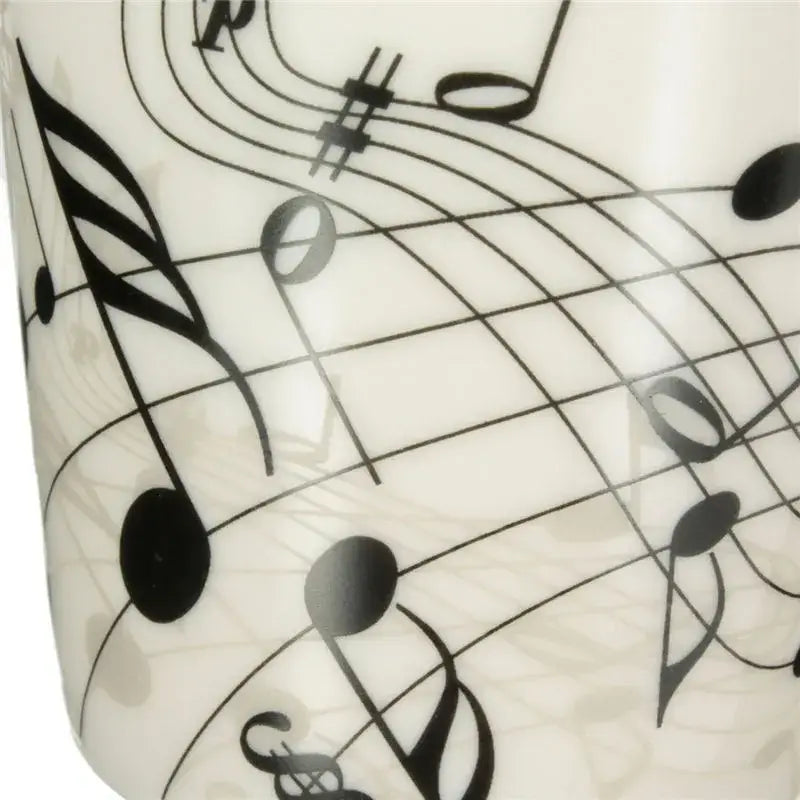 White ceramic acoustic guitar mug decorated with black musical notation for coffee or tea by DecorBites