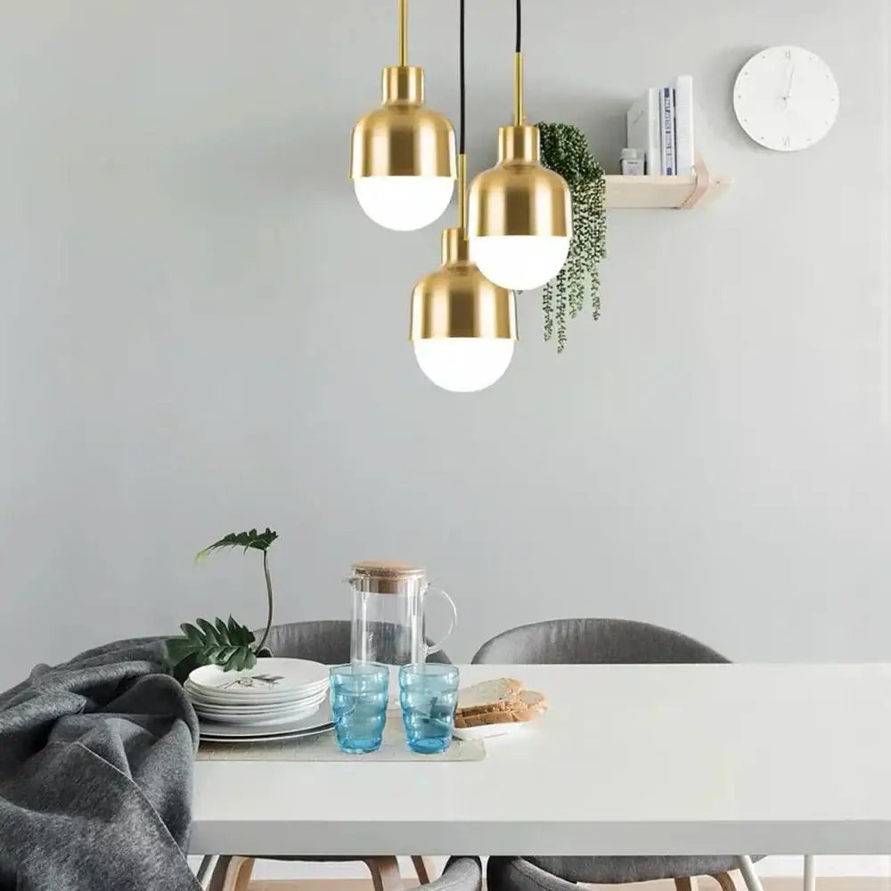Gold-toned DecorBites™ acrylic ball pendant light with frosted glass globes above modern dining table