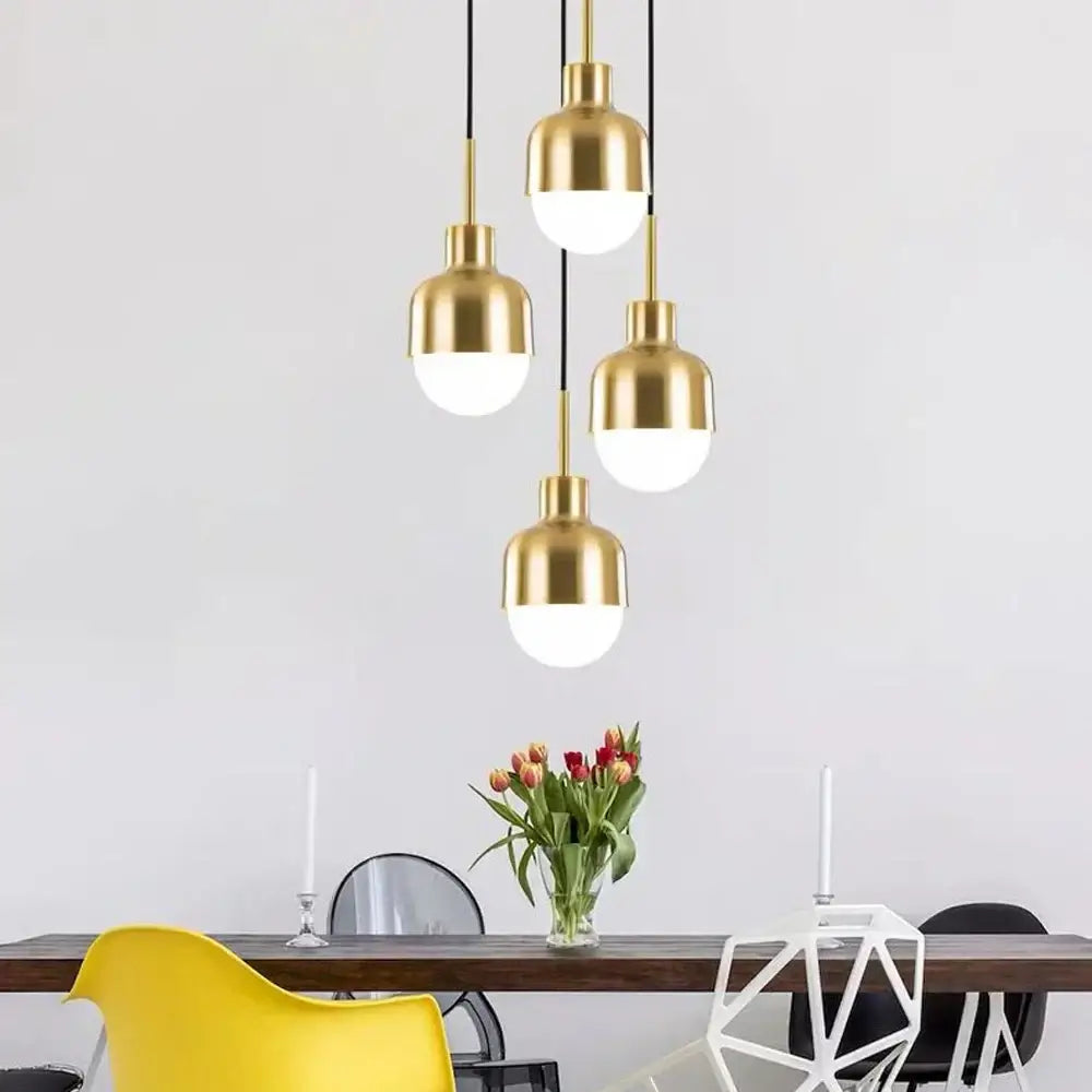 Gold-toned DecorBites acrylic ball pendant lights with frosted glass shades hang from black cords above dining table