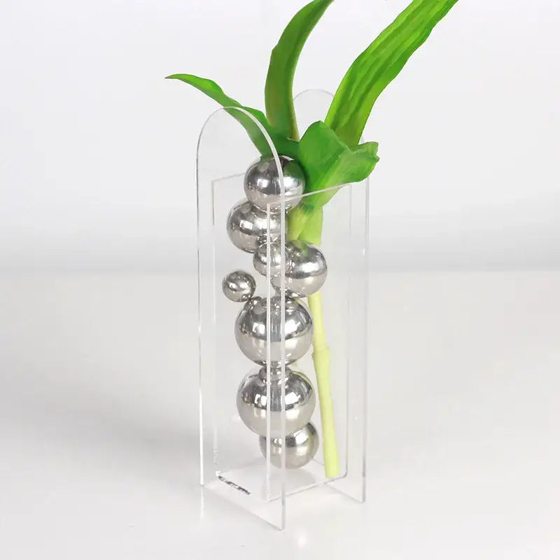 Clear acrylic ball vase stack with sleek silver metallic spheres and green foliage by DecorBites™ for home decor