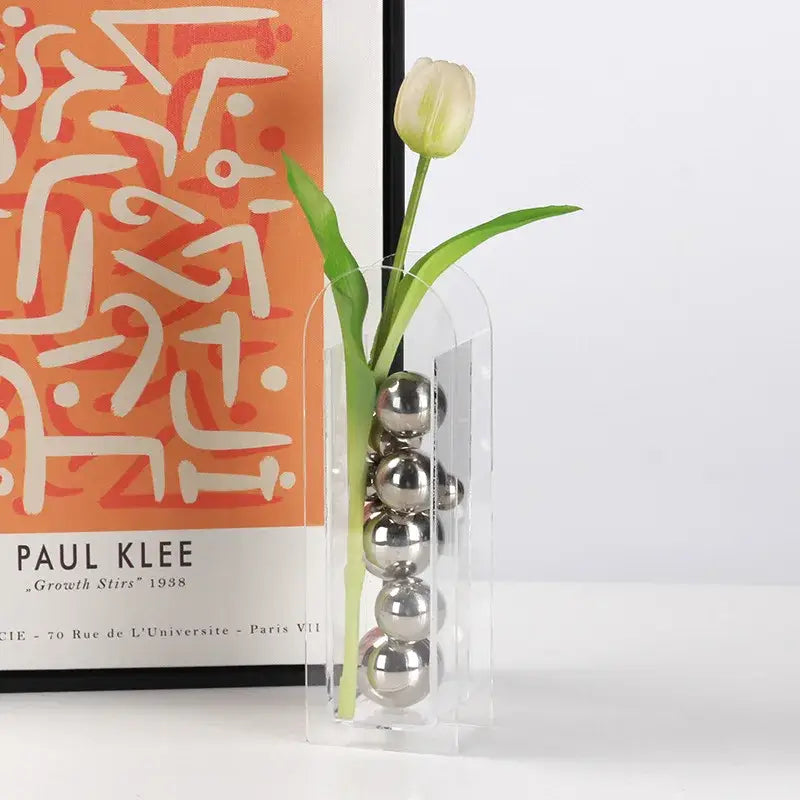 DecorBites acrylic ball vase stack with clear curved acrylic vase holding silver spheres and pale green tulip