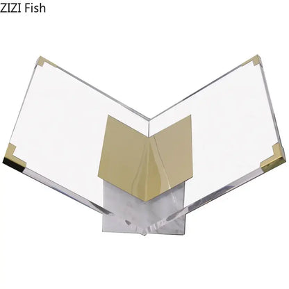 Clear acrylic bookshelf with gold-tone metal corners and v-shaped support on marble base for modern home decor