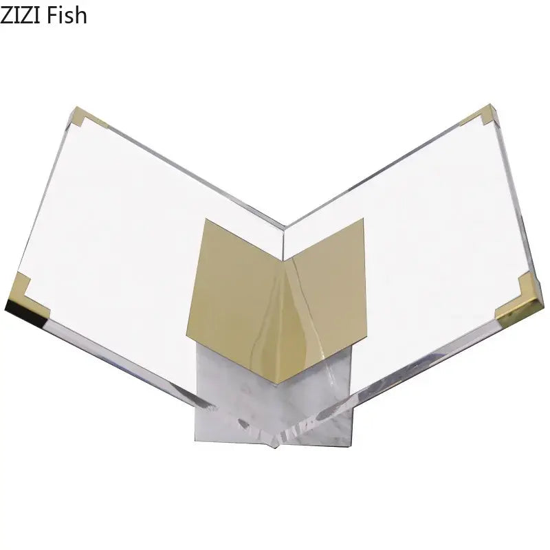 Clear acrylic bookshelf with gold-tone metal corners and v-shaped support on marble base for modern home decor